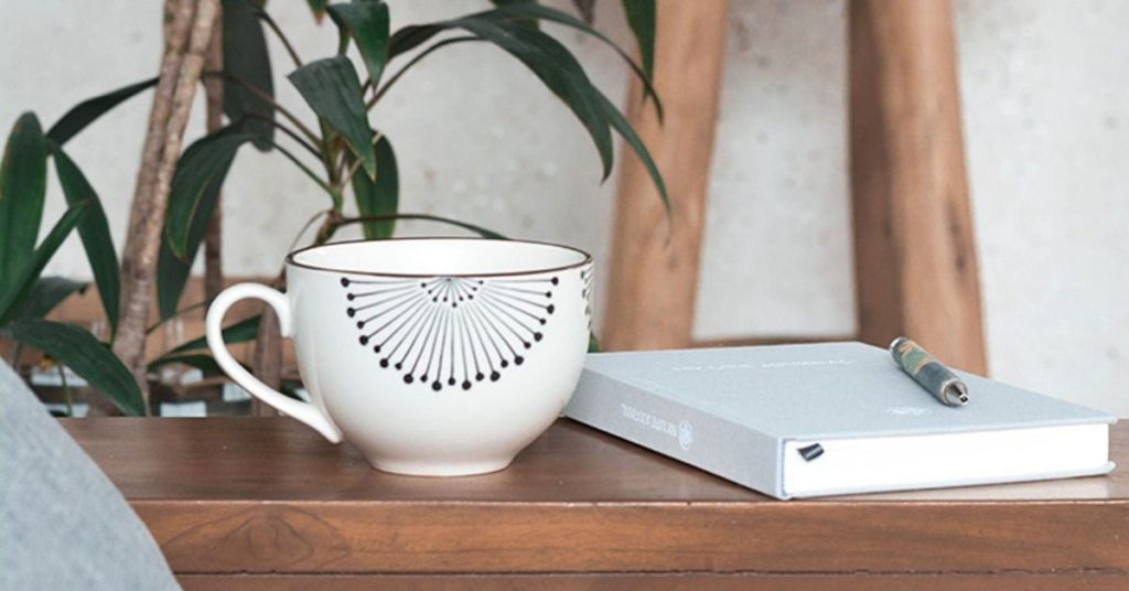 large coffee cup and notebook on a table