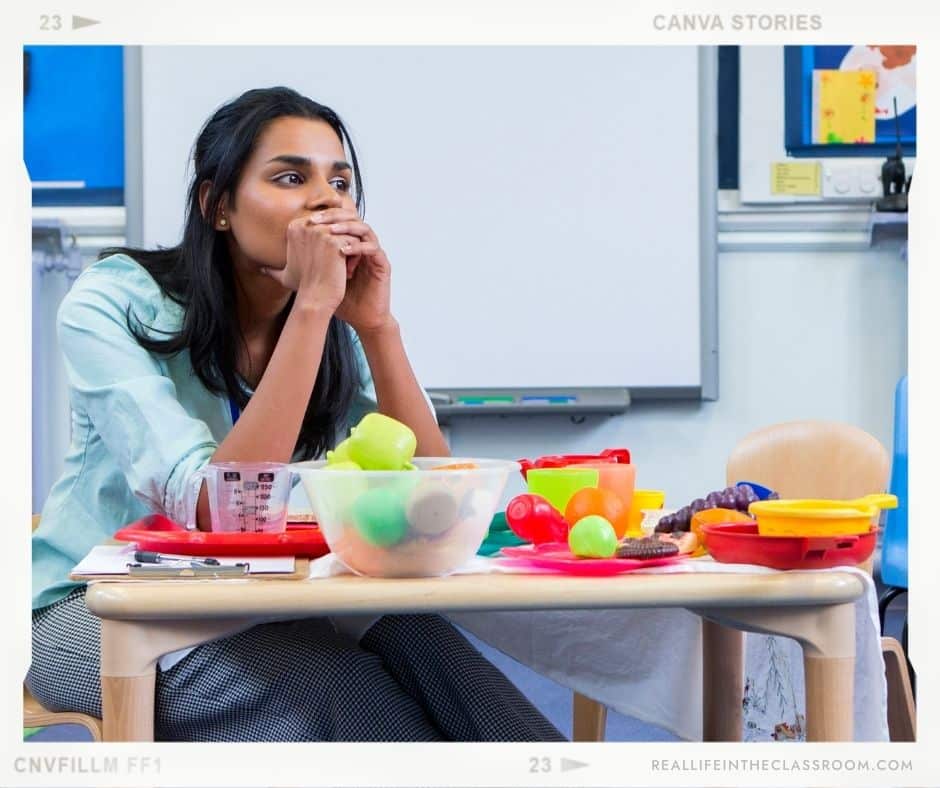A teacher sitting alone at a table looking stressed out and overwhelmed on the first day of school