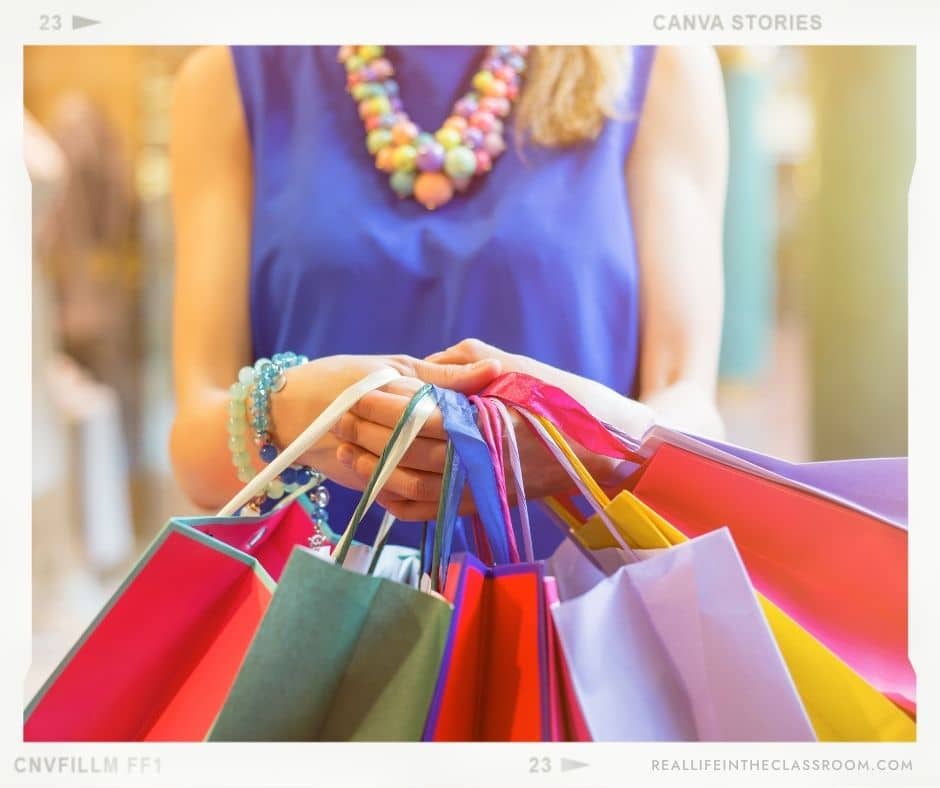 A teacher holding shopping bags filled with all the things she bought for her classroom and students with her own money