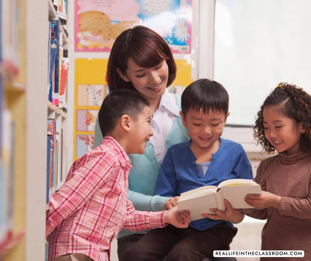 a teacher looking at a book with some students