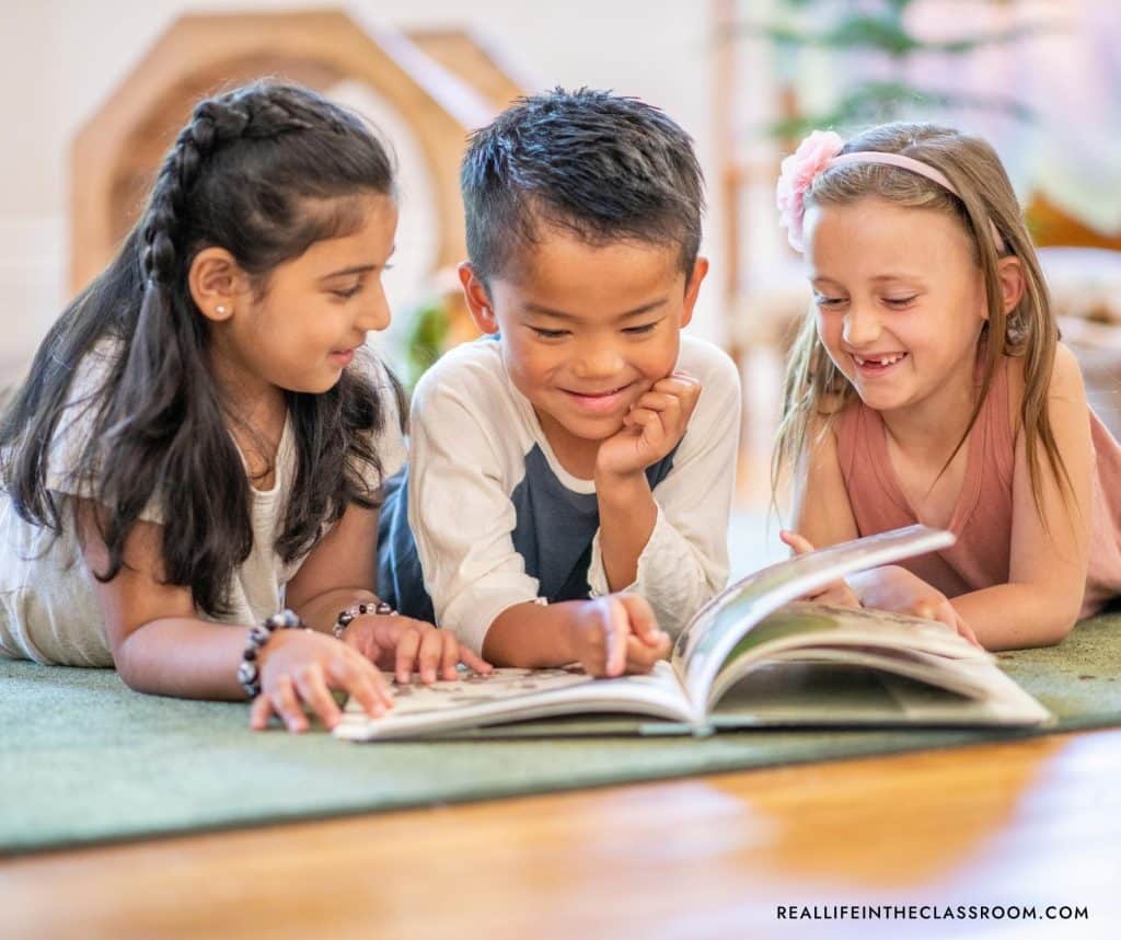 three students reading a book together on the rug