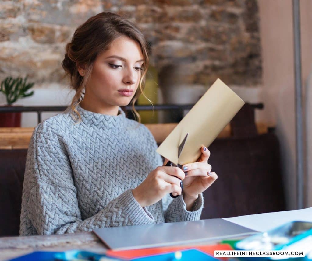 a teacher cutting out bulletin board letters